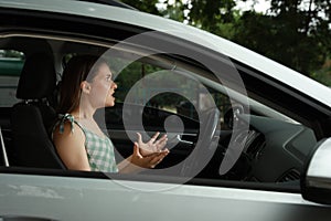 Stressed young woman in driver`s seat of modern car