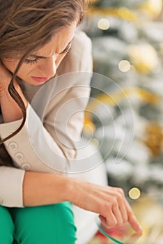 Stressed young woman in front of christmas tree