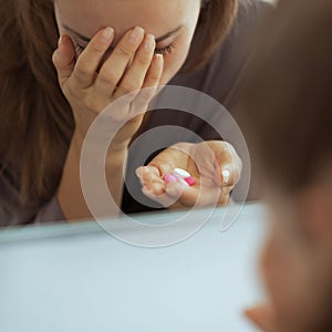 stressed young woman with pills in bathroom