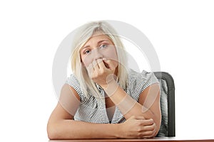 Stressed young woman sitting behind a desk