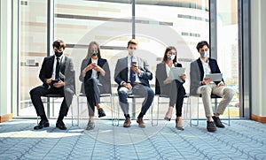 Stressful business people waiting for job interview with face mask, social distancing quarantine during COVID19 affect