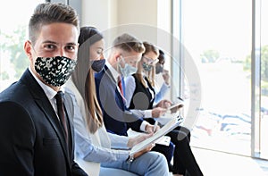 Stressful business people waiting for job interview with face mask, social distancing quarantine during COVID19 affect