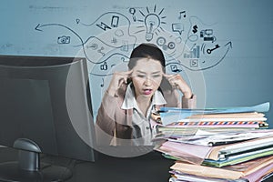 Stressful businesswoman looks at a pile of documents