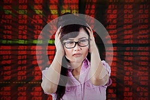 Stressful female broker with stock exchange background