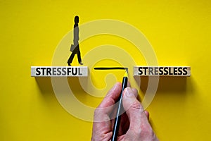 Stressful or stressless symbol. Blocks with words stressful, stressless. Yellow background. Businessman hand, businesswoman icon.