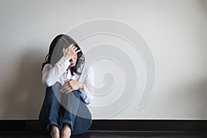 Stressful woman sitting sadly with emotional depression and anxiety on the floor photo