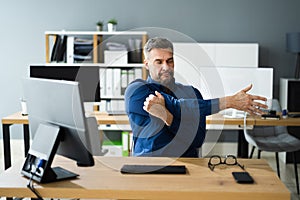 Stretch Exercise At Office Desk At Work