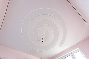 Stretch matte white ceiling in the interior of a square room