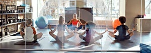 Stretch and relax. Full-length shot of kids meditating, sitting in Lotus pose, doing yoga exercises together with female