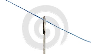 Stretched blue thread through the eye of a needle over a white background.