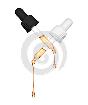 Stretched oily drops are falling from a cosmetic pipettes close-up on a white background photo