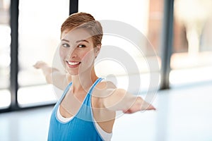 Stretched and unstressed. a young woman practising yoga at the gym.