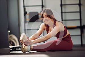 Stretching exercises. Young beautiful woman in sportive clothes have fitness day in the gym