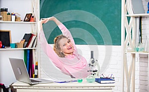 Stretching after hard working day. Teacher adorable woman try to relax in classroom. Mental health and relaxation