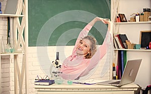 Stretching after hard working day. Teacher adorable woman try to relax in classroom. Mental health and relaxation