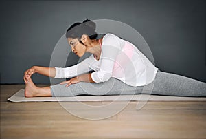 Stretching her way to a stressless life. a young woman stretching during her yoga routine.