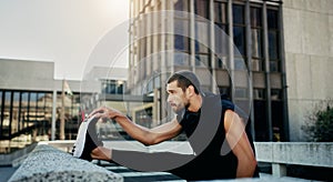 Stretching legs, fitness and man in city for warm up, cardio workout or endurance training. Outdoor, sports and athlete