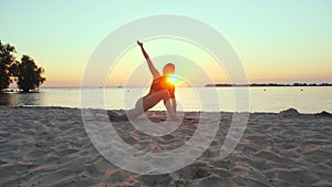 stretching outdoors. yoga silhouette. yoga beach. Athletic young woman is practicing yoga at the beach during sunset or