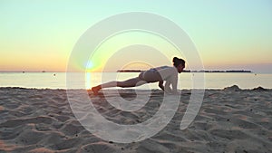 stretching outdoors. yoga silhouette. yoga beach. Athletic young woman is practicing yoga at the beach during sunset or