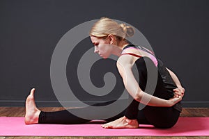 Stretching. Young blonde woman doing yoga exercise photo