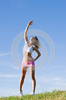 Stretching young sportive woman meadows sunny day