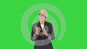 Strict Attractive Senior Woman Talking To Camera on a Green Screen, Chroma Key.