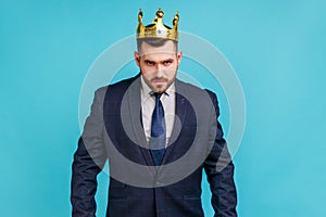 Strict bossy man in official style suit and golden crown, being on position of top manager or boss