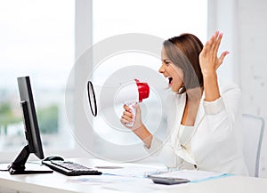 Strict businesswoman shouting in megaphone