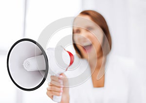 Strict businesswoman shouting in megaphone