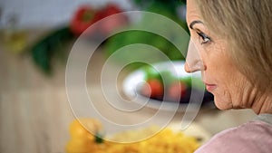 Strict female face, scolding wife home kitchen, annoyed lady closeup, skepticism