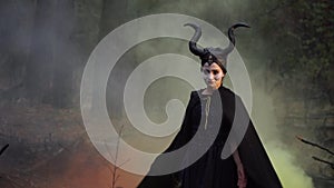 Strict girl in the image of Maleficent in a mystical and secret forest