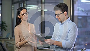 Strict lady boss unhappy with work of young trainee, checking his report, fail