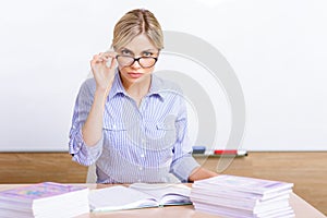 Strict-looking teacher sitting at the desk