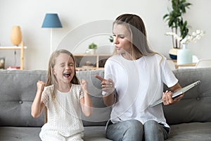 Strict mom scolding ill-behaved daughter screaming loud at home