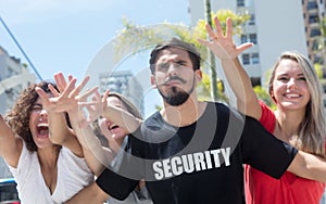 Strict security guard with groupies at concert