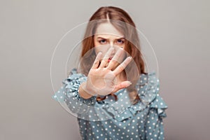 Strict serious bossy girl ruffle blouse keeping outstretched hand up, showing stop no prohibition gesture, warning