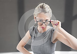 Strict teacher looking through glasses with serious expression