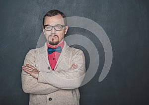 Strict teacher vintage style in eyeglasses looking at you on blackboard