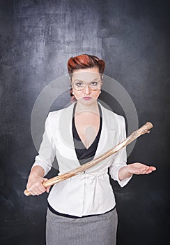 Strict teacher with wooden stick on blackboard background