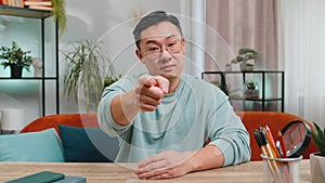 Strict unhappy Asian man pointing finger to camera looking angry making choice accusing for mistake