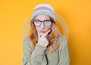 Strict young woman, isolated on yellow background. Jealous pretty woman