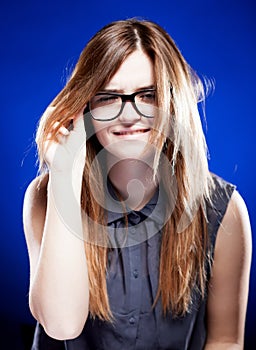Strict young woman with nerd glasses, giddy grimace photo