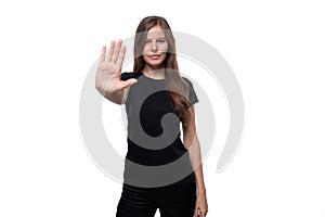 Strict young woman with straight hair shows a gesture of disagreement and stop