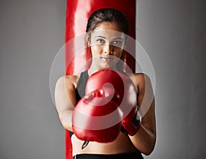 Strike first. Cropped portrait of an attractive young female boxer training in the gym.