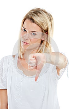 Strike three. Youre out. Studio portrait of a young woman giving thumbs down against a white background.