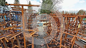 A rustic scrapyard filled with rusty metal frames and various industrial items for collection
