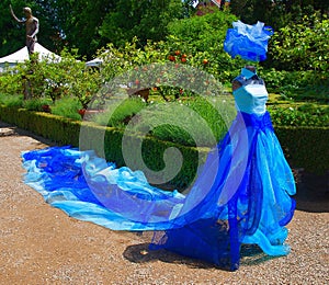 A striking fabric figure gliding in a garden