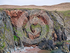 Striking mixes of different grey and red rock types in the coastal cliffs on the Ness of Hillswick in Northmavine, Shetland