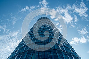 Skyscraper with Geometric Glass Facade and Cloudy Sky