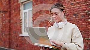 Striking woman deeply engrossed in distance working in personal laptop outdoors